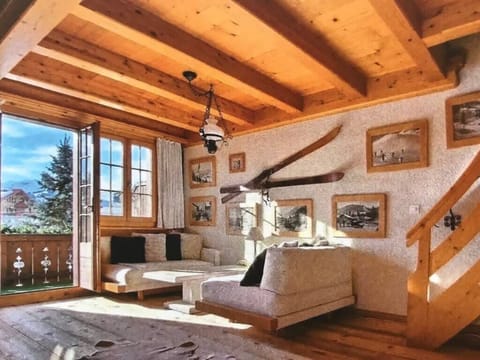 The living room, designed with an alpine theme, is located in front of the balcony.