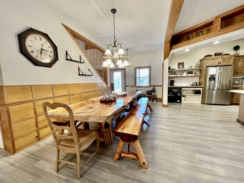 Extra large dining table, front door and partial kitchen view