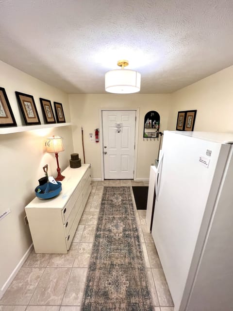Laundry room with overflow refrigerator and dresser with extra home supplies. 
