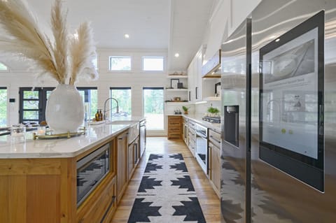 A chef’s dream kitchen with high-end stainless steel appliances, ample counter space, and a stylish combination of modern and rustic design elements for a luxury cooking experience.