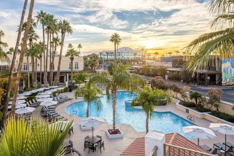 Unwind at sunset beside the sparkling resort pool oasis.
