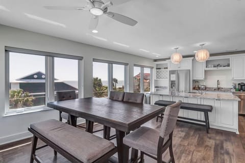 - Gather for meals around this stylish dining table with bench seating and padded chairs
- Large windows fill the space with sunlight and offer views of palms and rooftops
- Ceiling fan and open layout make this an inviting indoor retreat