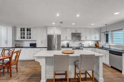 - Chef’s kitchen offers a full suite of stainless steel appliances, extrs counter space, & sleek modern finishes
- Center island invites conversation while you prep meals or sip morning coffee
- Adjoins a cozy dining nook with wood table seating for guests