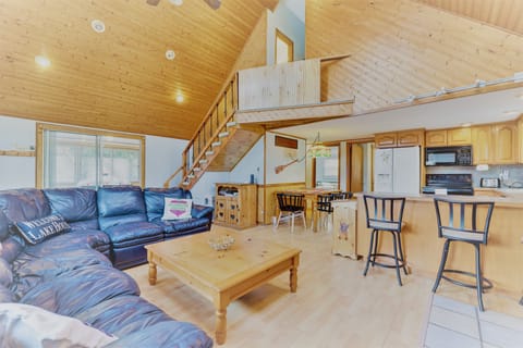 Another view of the living room showing the kitchen and bar seating.