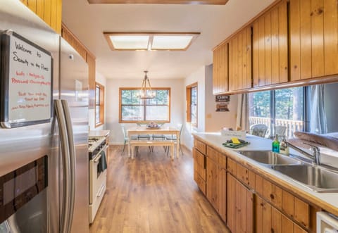 A bright and airy cabin kitchen flows into a dining area, offering a welcoming space for family meals and memories.