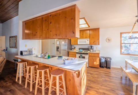 A spacious, wood-finished kitchen with a welcoming breakfast bar offers a perfect spot for morning gatherings in a cabin atmosphere.