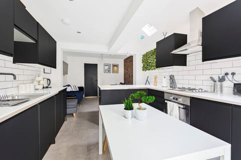 A fully equipped kitchen with fridge freezer, oven, stove, microwave, kettle, toaster, dishwasher, cookware, tableware, and utensils all provided