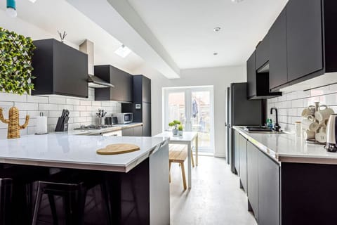 A fully equipped kitchen with fridge freezer, oven, stove, microwave, kettle, toaster, dishwasher, cookware, tableware, and utensils all provided