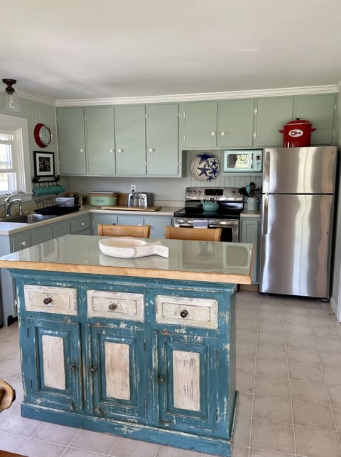 Island with 2 stools and kitchen