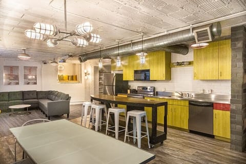 A large, open-concept space features a full kitchen, a dining area and giant living room complete with a projector and screen.