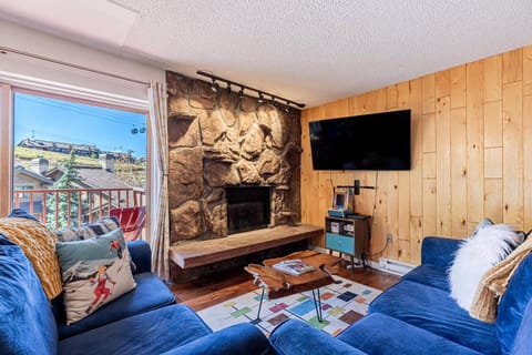 Cozy mountain retreat with stone fireplace, warm wood accents, and gondola views right from the living room.