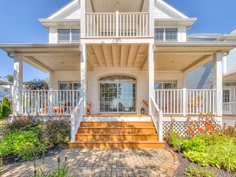 Large, waterfront home with balcony and patio at the front