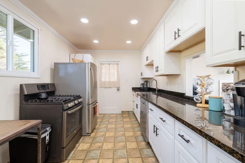 Fully equipped kitchen with fridge, oven, sink, and coffee corner
