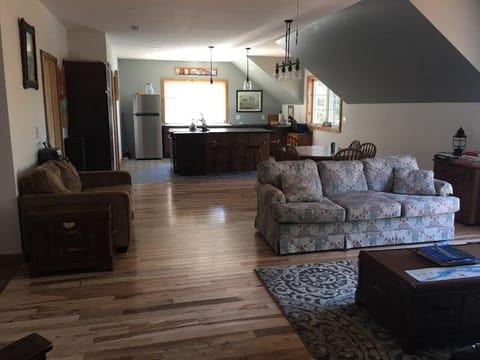 Open concept living space, dining room and kitchen. Hardwood flooring. 