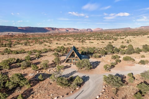 Drone shot of the Juniper House with Capitol Reef in distance