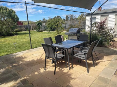 Patio area with BBQ and large backyard.