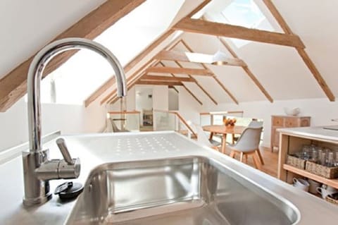 Kitchen looking across glass walkway towards snug