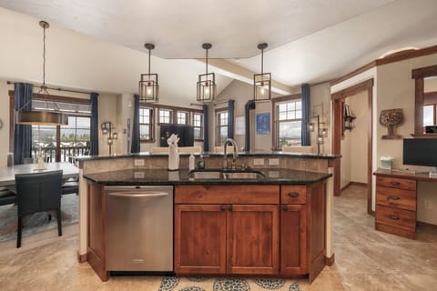 - Open kitchen island with sink and pendant lights above   - Spacious counters ideal for preparing meals or cocktails   - Layout flows to living and dining for entertaining guests
