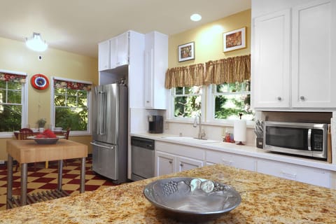 Upper level kitchen with stainless steel refrigerator, dishwasher, microwave.