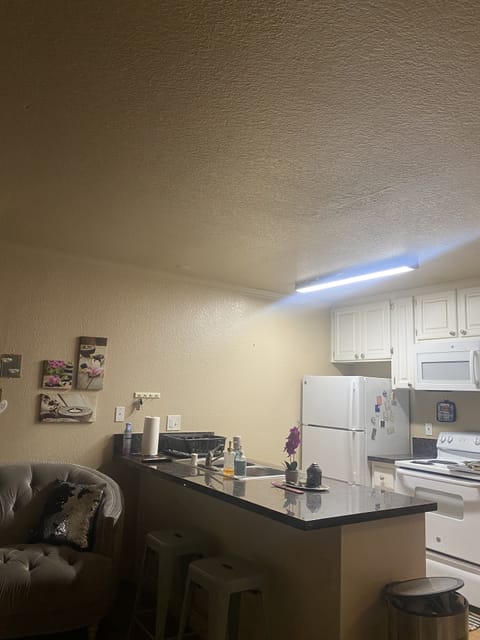 Open kitchen with bar stools for eating.