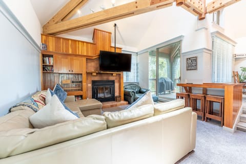 Living area featuring vaulted ceilings, fireplace, and cozy furnishings.