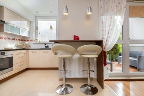 A well-lit open-plan kitchen with a dining area, featuring modern furnishings and stylish decor.