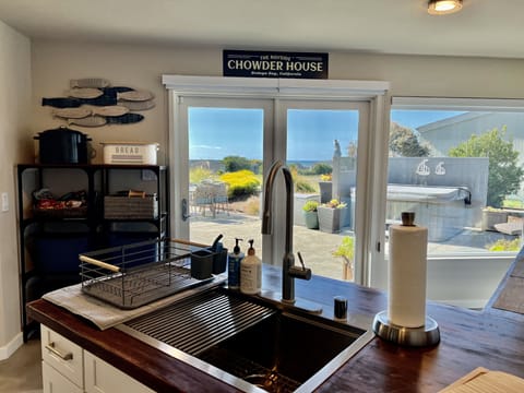 Looking out from kitchen sink to hot tub, patio, golf course and seas beyond.