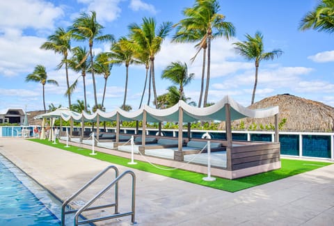 Bask in resort luxury on shaded daybeds by the water.