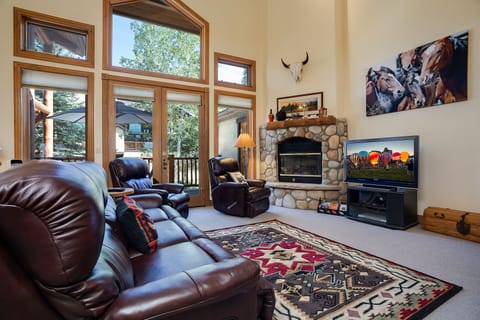 Sink into rich leather seating by your crackling stone fireplace, where rustic charm meets modern comfort for perfect evenings in.