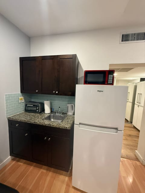 Enjoy the comfort of a fully equipped kitchenette featuring a Whirlpool refrigerator, microwave, and toaster oven for quick and easy meals. The space includes a granite countertop, sink with faucet, electric kettle, and ample cabinet storage.