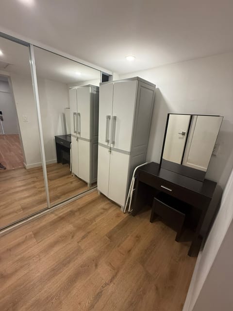 Enjoy a well-organized and comfortable stay in this thoughtfully furnished room featuring a sleek, dark wood vanity with mirror and matching stool perfect for your daily routines or work-from-home needs. You'll have access to two tall storage cabinet