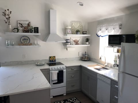 Fully stocked kitchen with dishwasher, full stove, coffee pot and tea pot. 

