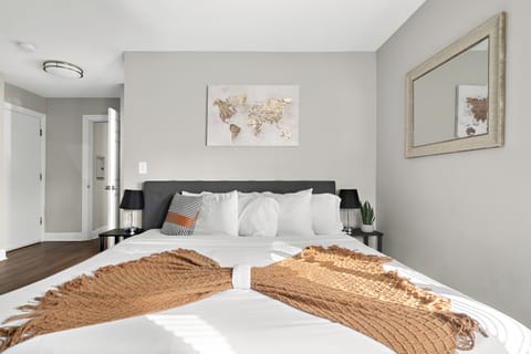 King size bed in master bedroom with soft pillows sheets and comforters. 