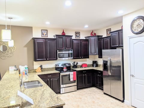 kitchen wall all stainless steel appliances, granite countertop, pantry