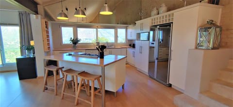 The kitchen is light and airy, with a central island around the gas cooker