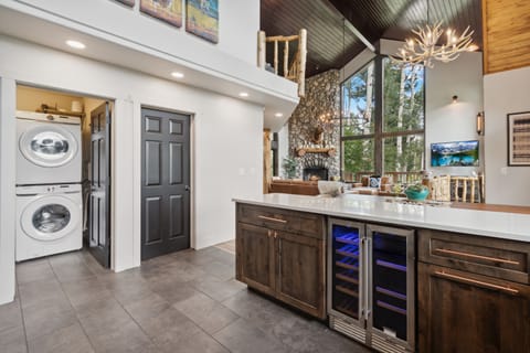 Laundry room is off of the open kitchen, has two stacked washer/dryer sets.