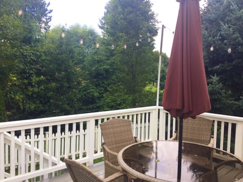 Carriage house back deck with stairs down to fenced yard.