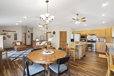 Kitchen table, living room on left, refrigerator, island, microwave, range/oven