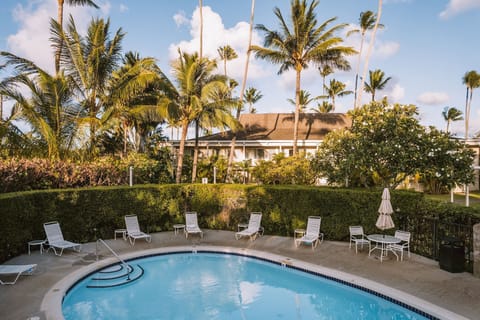 Unwind on sun loungers beside a sparkling tropical pool.