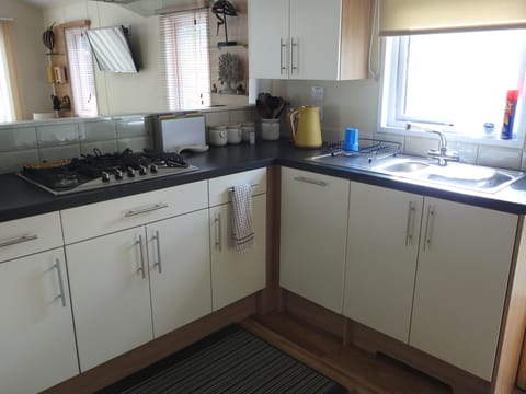 Kitchen- dishwasher behind door underneath drainer 