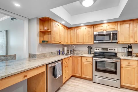 - L shaped counter layout with full size fridge, dishwasher, oven, and microwave
- Pass through opens to the dining area, great for serving and staying connected
- Warm finishes and sleek surfaces create a welcoming cooking space