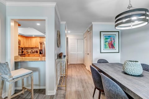 - Peek through kitchen opens to a stylish dining space and hallway beyond
- Bar seating makes a great spot for breakfast or evening wine
- Wood style flooring and curated artwork enhance the home's modern elegance