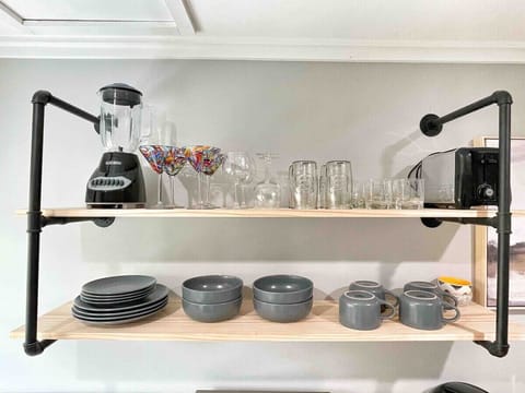 Well-organized open shelves with cookware, mugs, and essentials.
