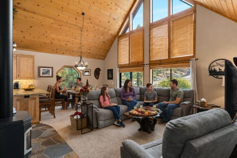 Gather in your expansive great room, where soaring ceilings and towering windows frame natural light. Relax on plush sectionals or share meals at the wooden table—perfect for creating vacation memories together.