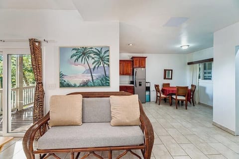 Open living and bedroom area with natural light, garden view, and a layout that 