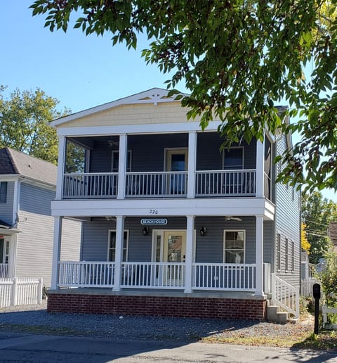 The front of the house features an open porch and screened-in balcony upstairs.