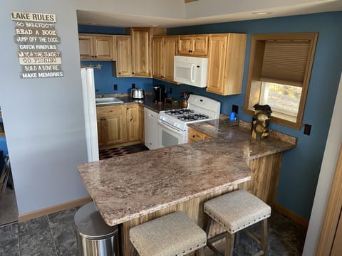 The full kitchen boasts an oven, gas range, fridge, microwave, and dishwasher.