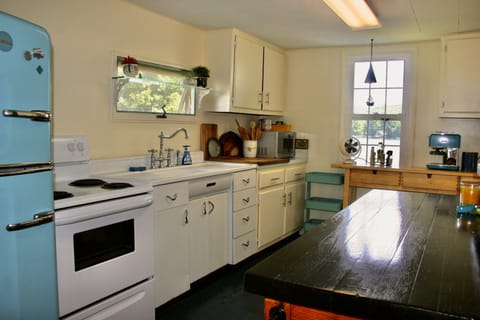 Kitchen fully stocked with coffee, plates, utensils, cooking pans, etc