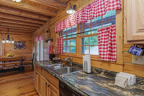 Wood cabinetry and cheerful red accents give the Peace of the Mountain kitchen a welcoming, nostalgic character perfect for family gatherings.