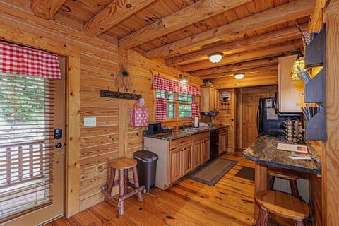 Open layout of the kitchen and dining area makes group meals simple, with warm wood tones and easy access to the porch for screened in outdoor dining.